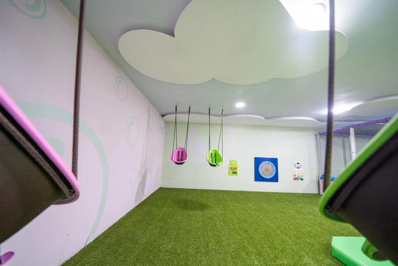 Zona para bebés con columpios y techo de nubes
